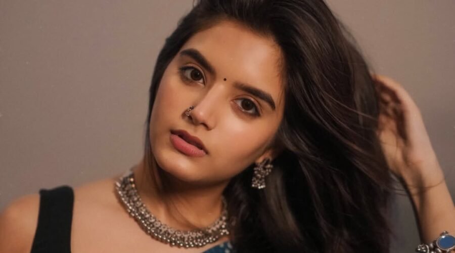 A women name priyanshi yadav with long hair wearing a blue sari and a necklace