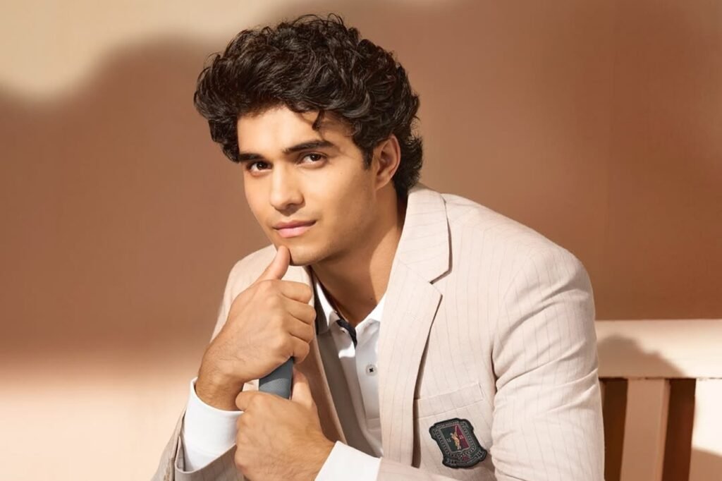 Abhay Verma wearing suit with cricket bat in hand